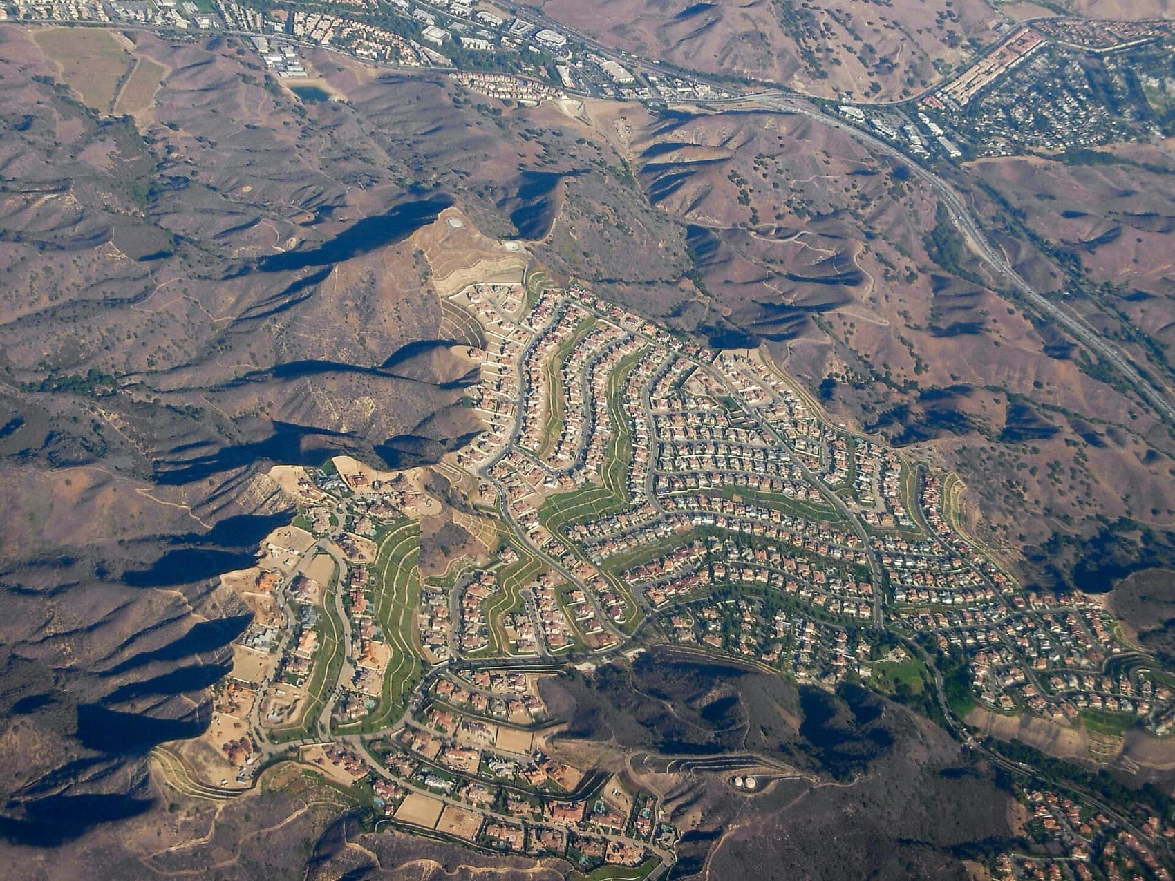Aerial view of hillside housing tracts and open ridgeline in Calabasas, California.